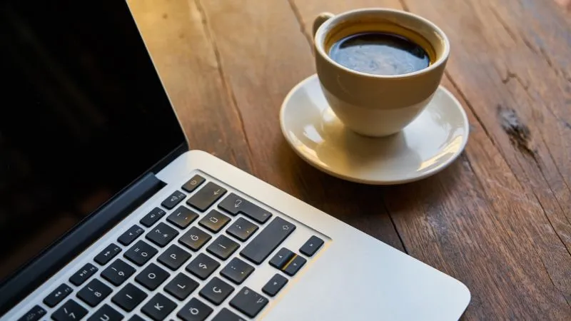trabajando desde casa como emprendedora digital. imágen de una computadora y una taza de café. ilustrativa