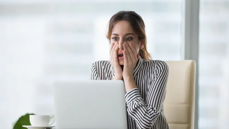 Imágen una mujer mirando su laptop presumiblemente dandose cuenta de un error