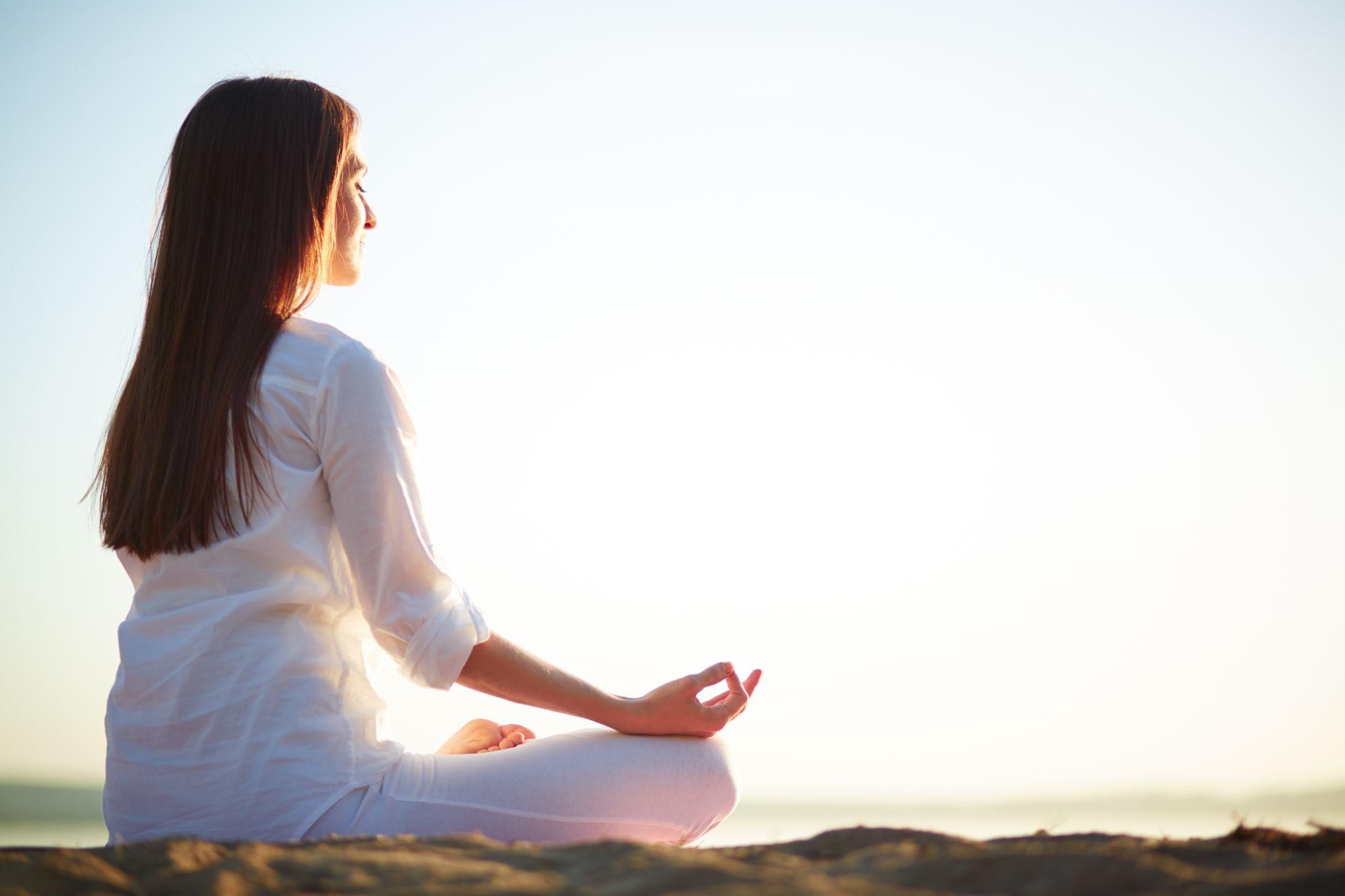 A woman meditating for healing in nature.