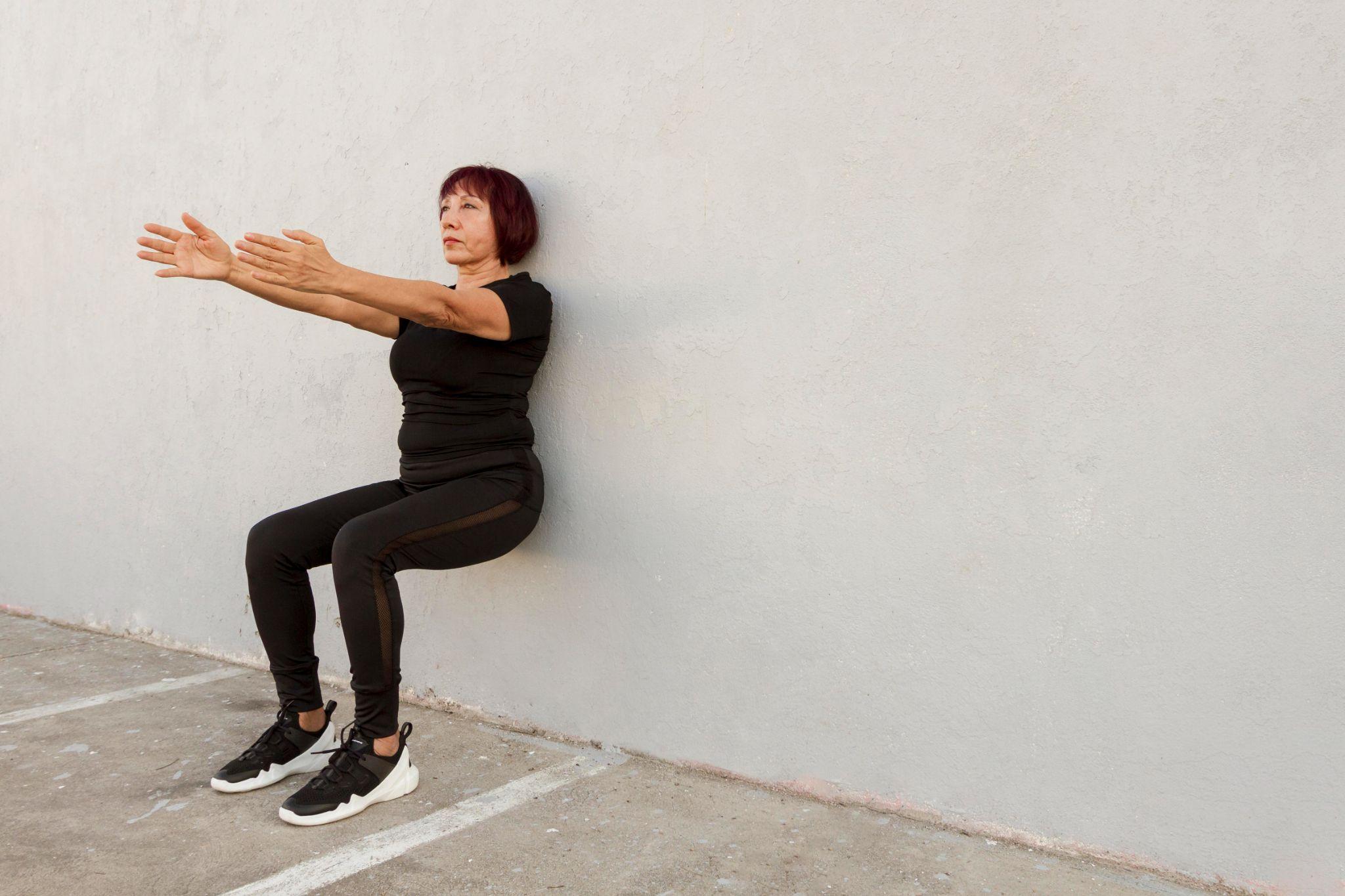 A woman doing wall squats.