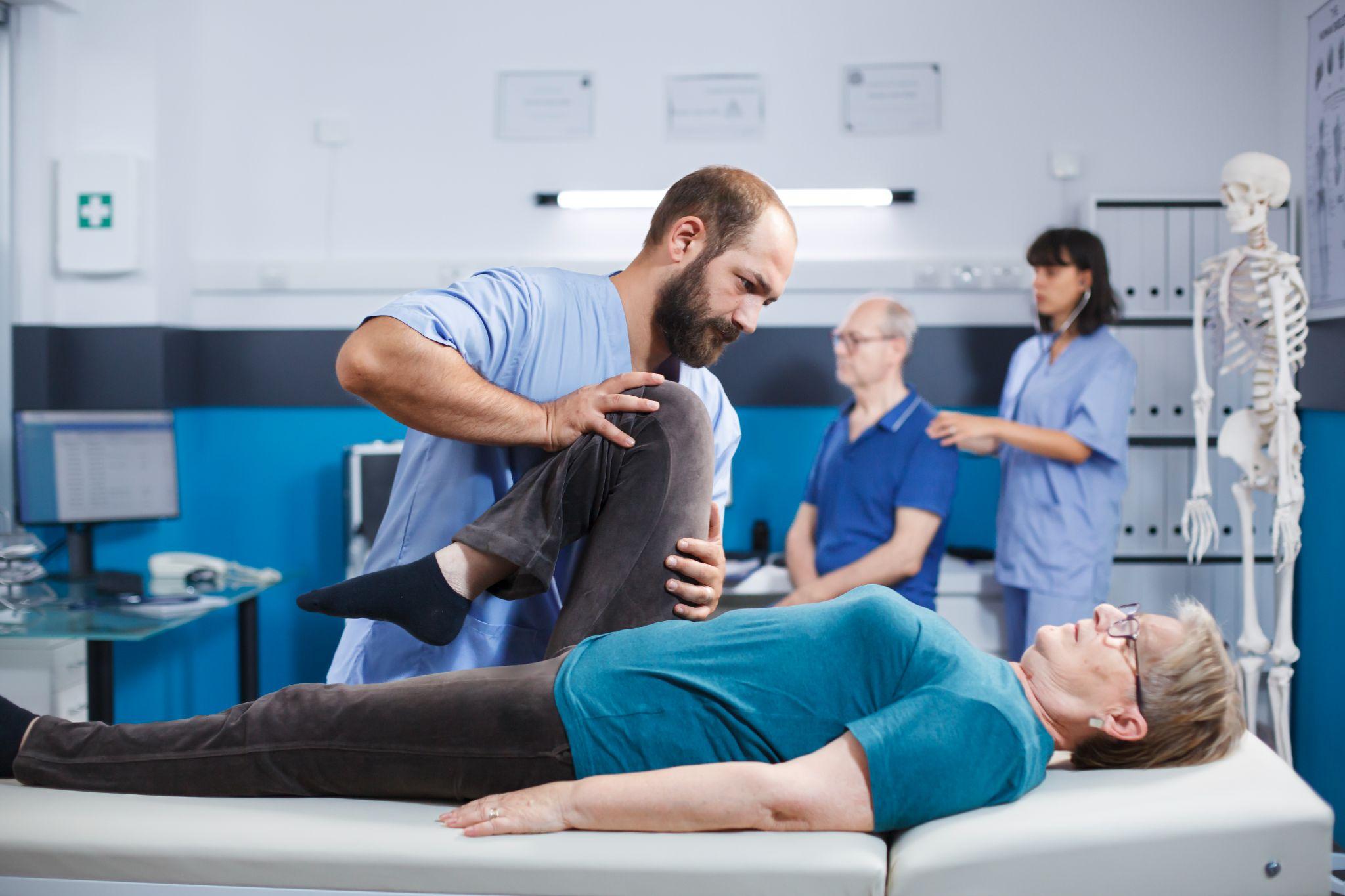 A doctor helping stretch the knee of a patient.