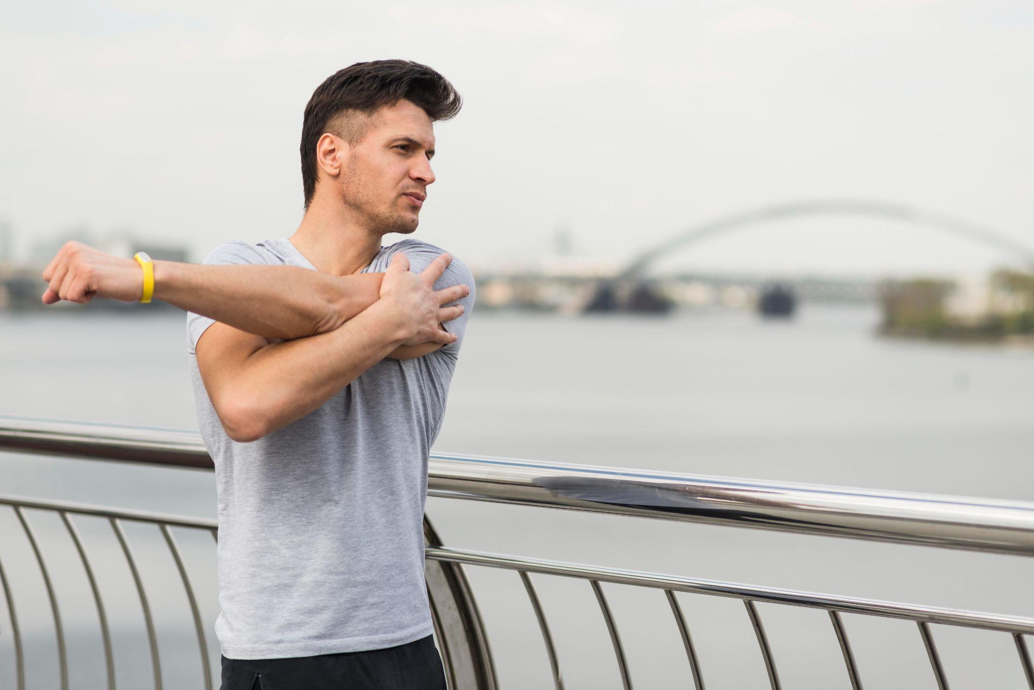 A man stretching his hand and shoulder.