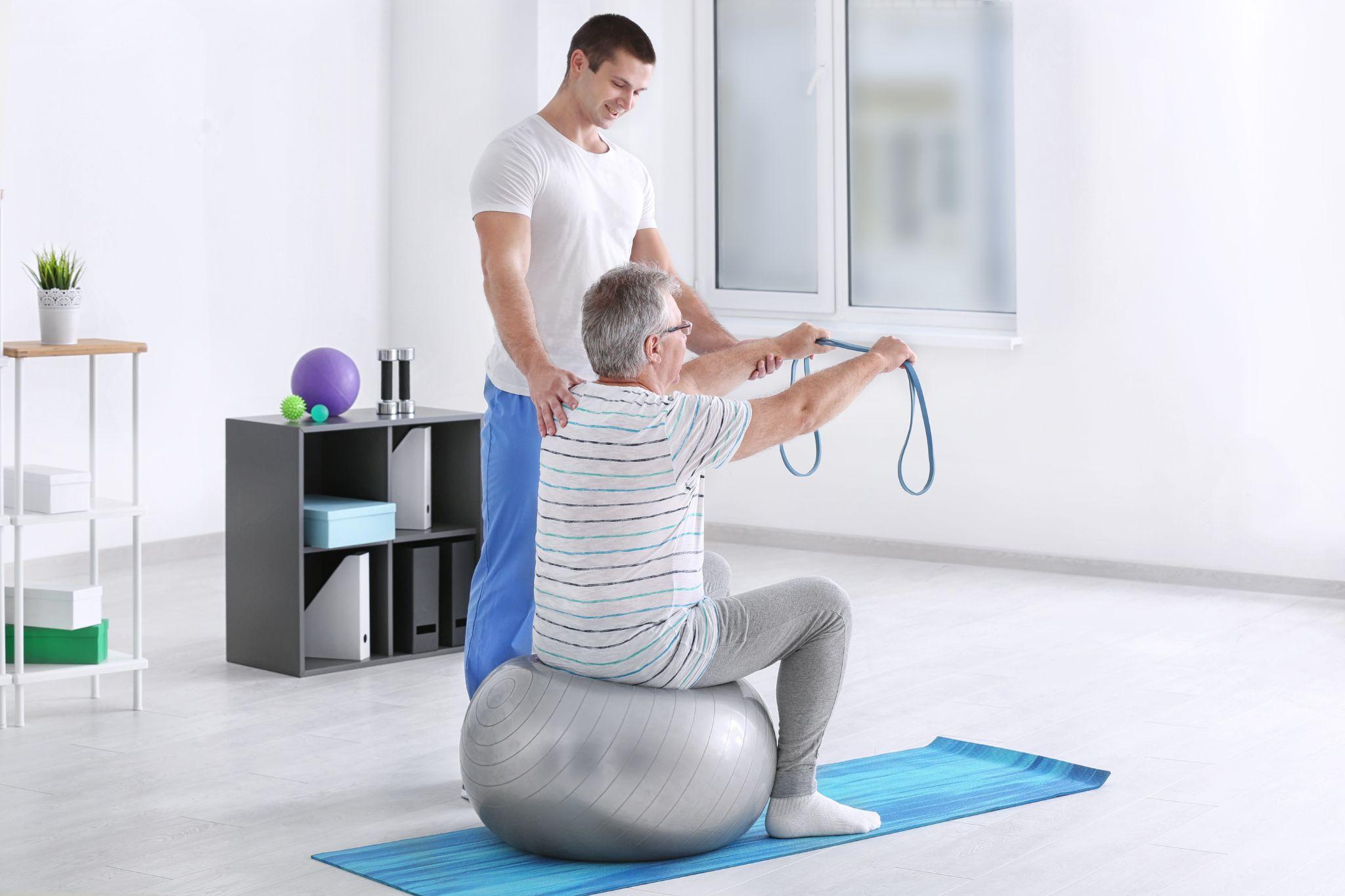 A man helping another man with physiotherapy.