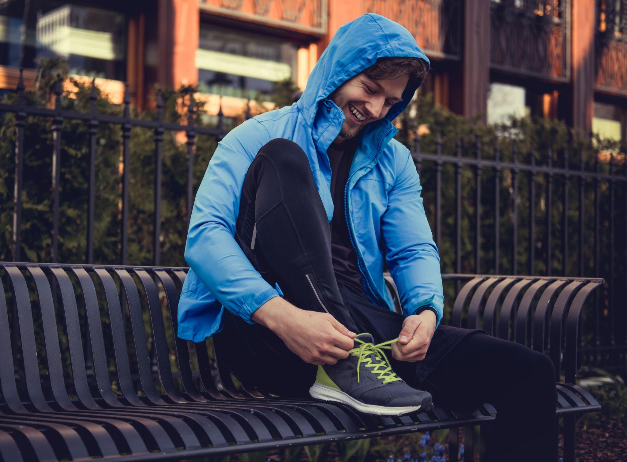A man tying his shoelace, while smiling.