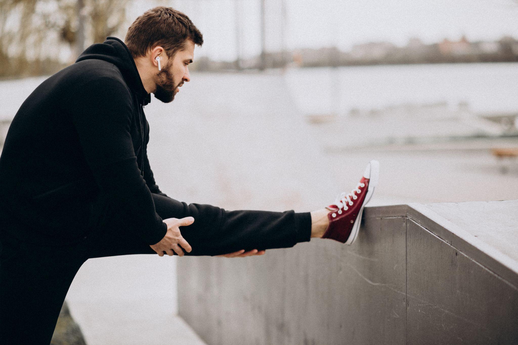 A man stretching his lega and calves.