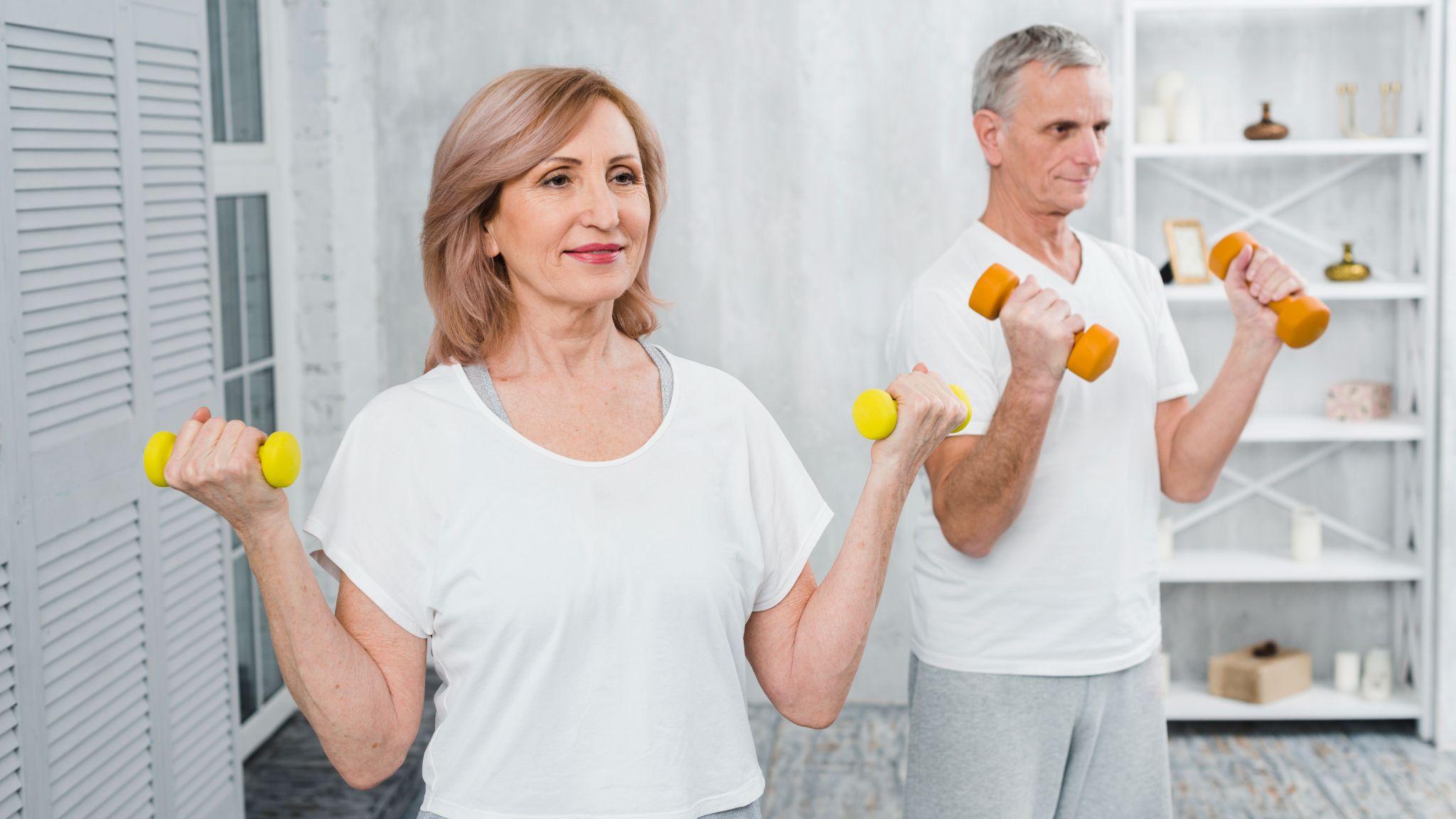 Two older adults working out with small dumbbells.