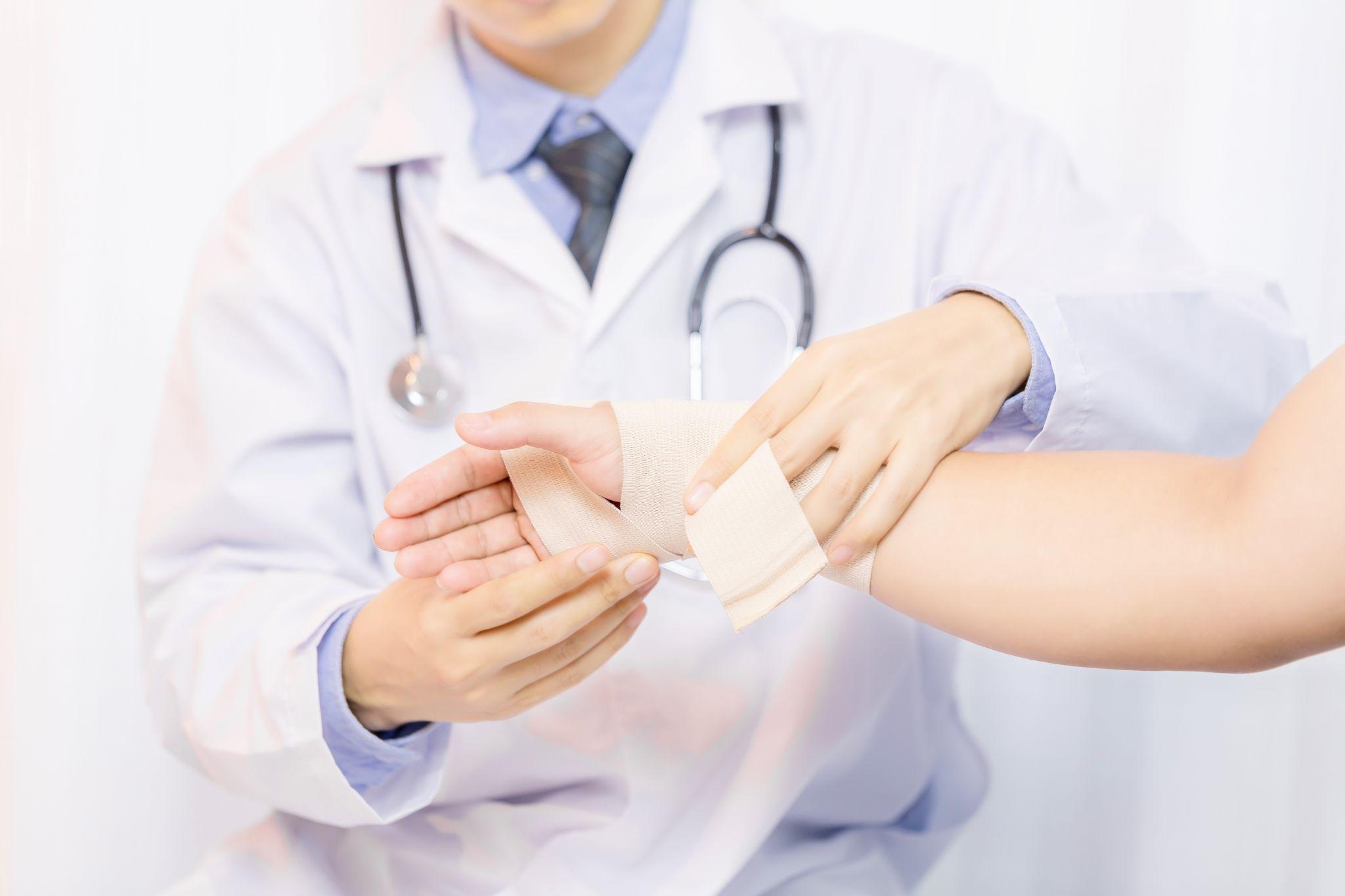 A doctor bandaging a patient’s hand.