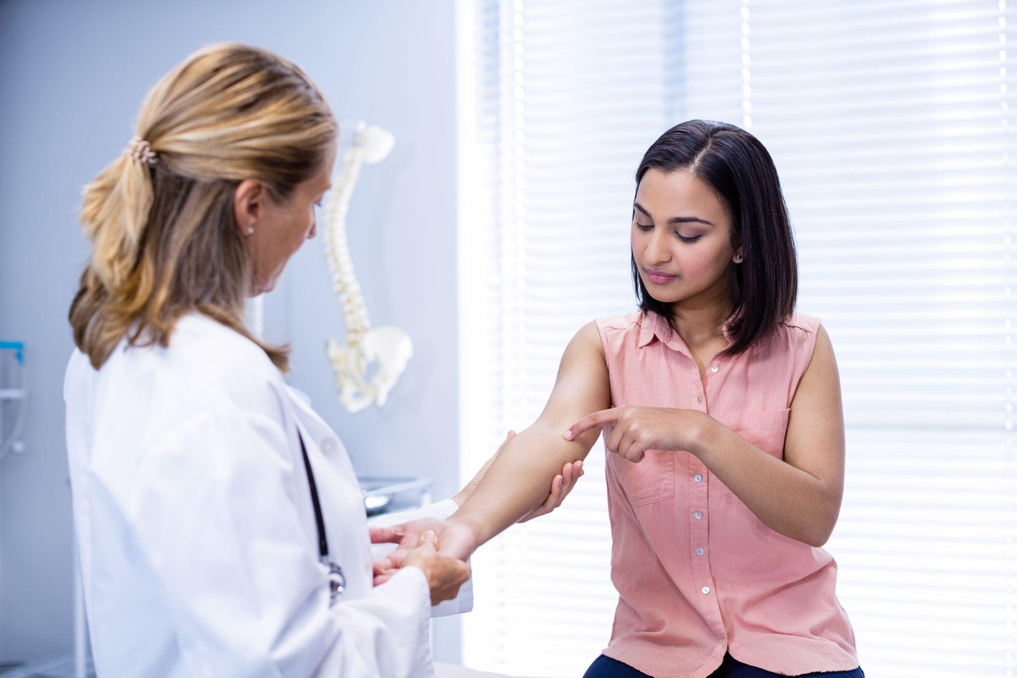 A doctor checking a patient’s hand.