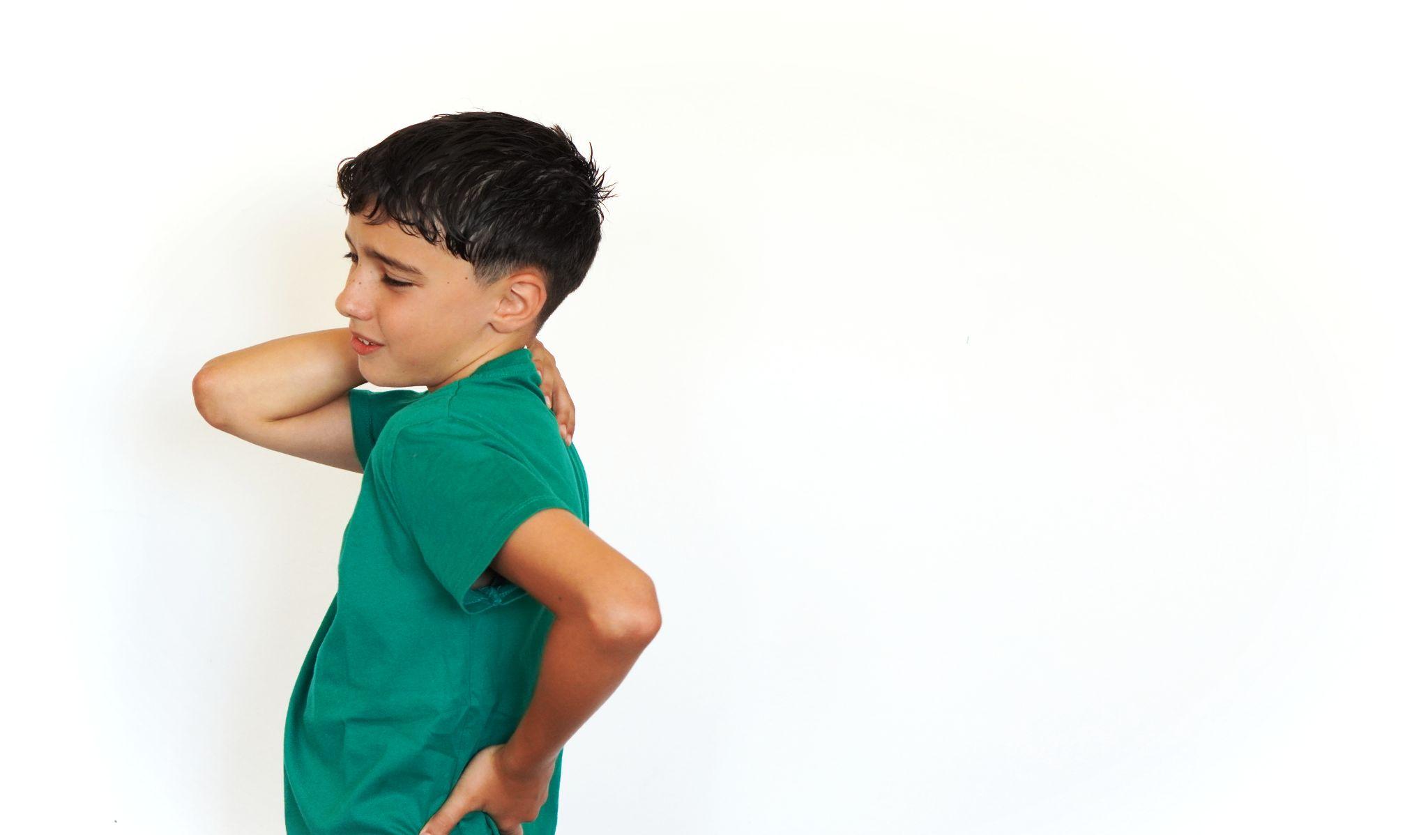 A boy holding his back.