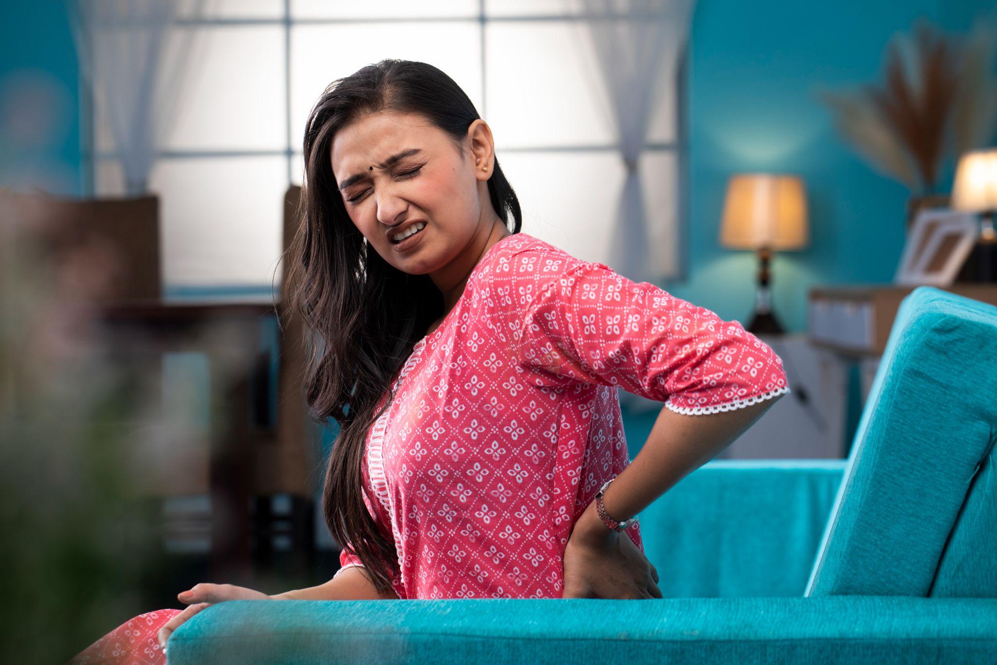 A woman holding her back.