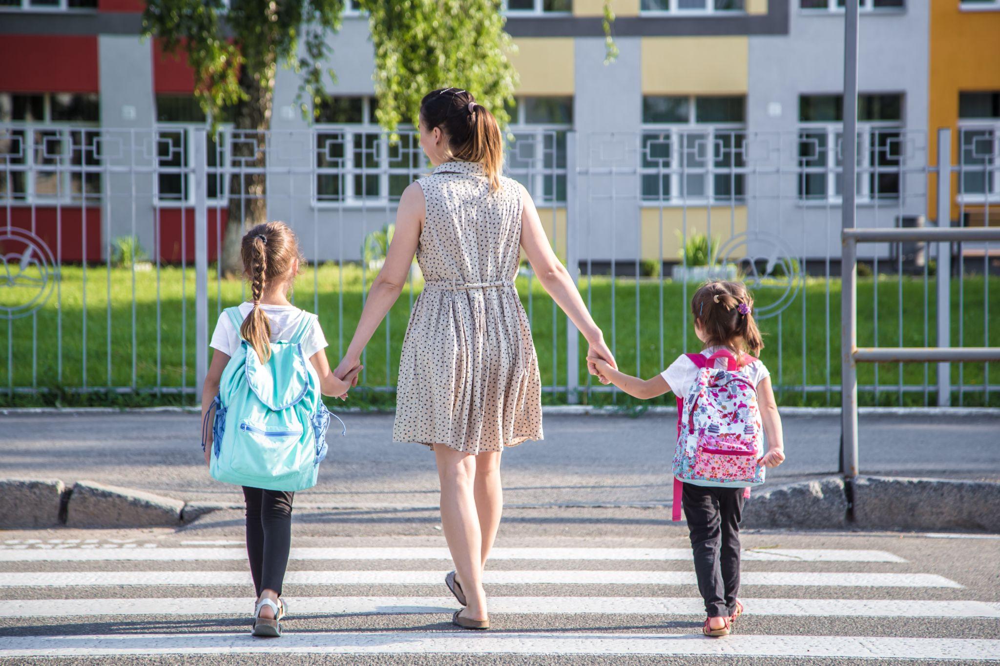 Children carrying backpacks to school.