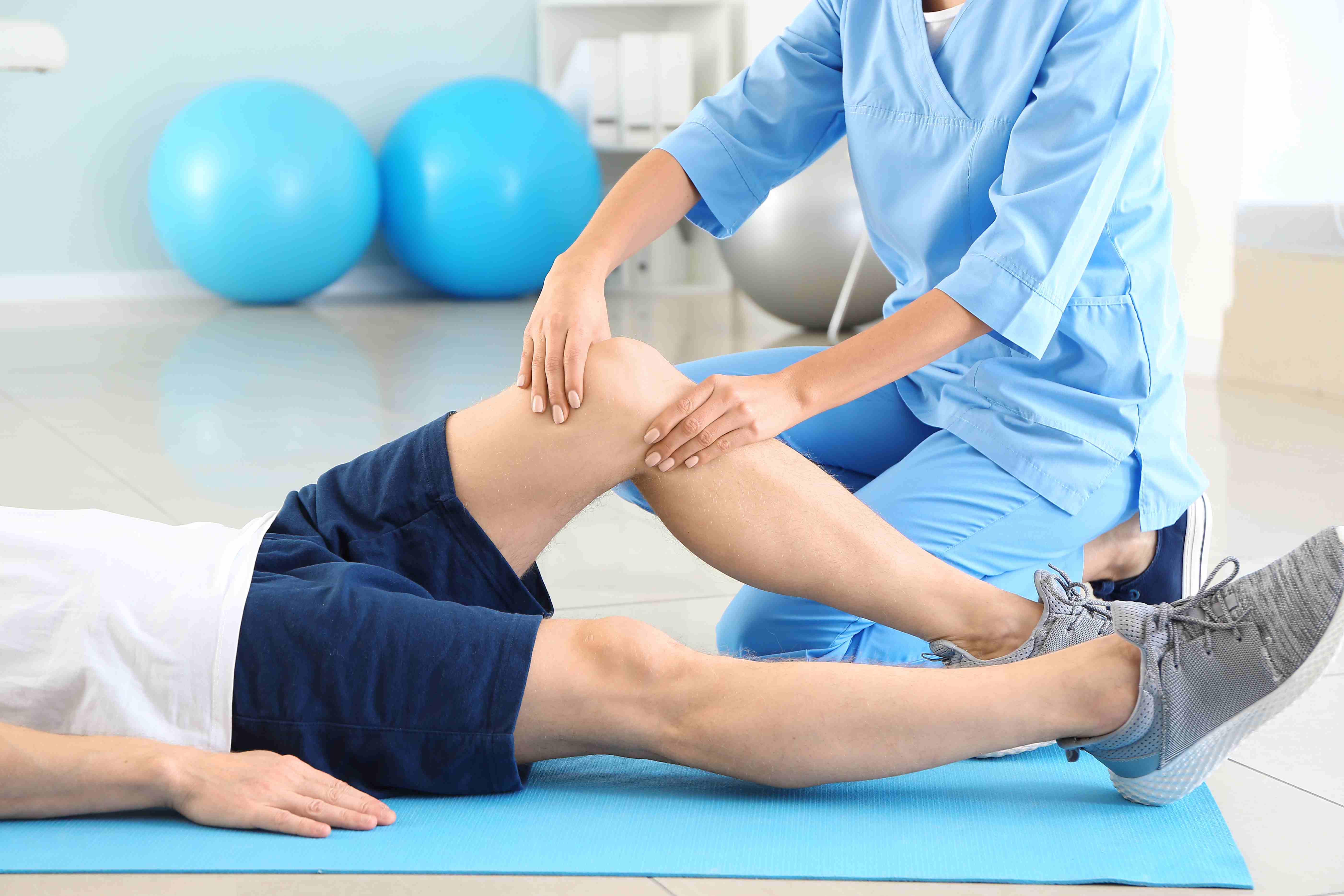 A physiotherapist helping a patient before and during their knee surgery preparation.