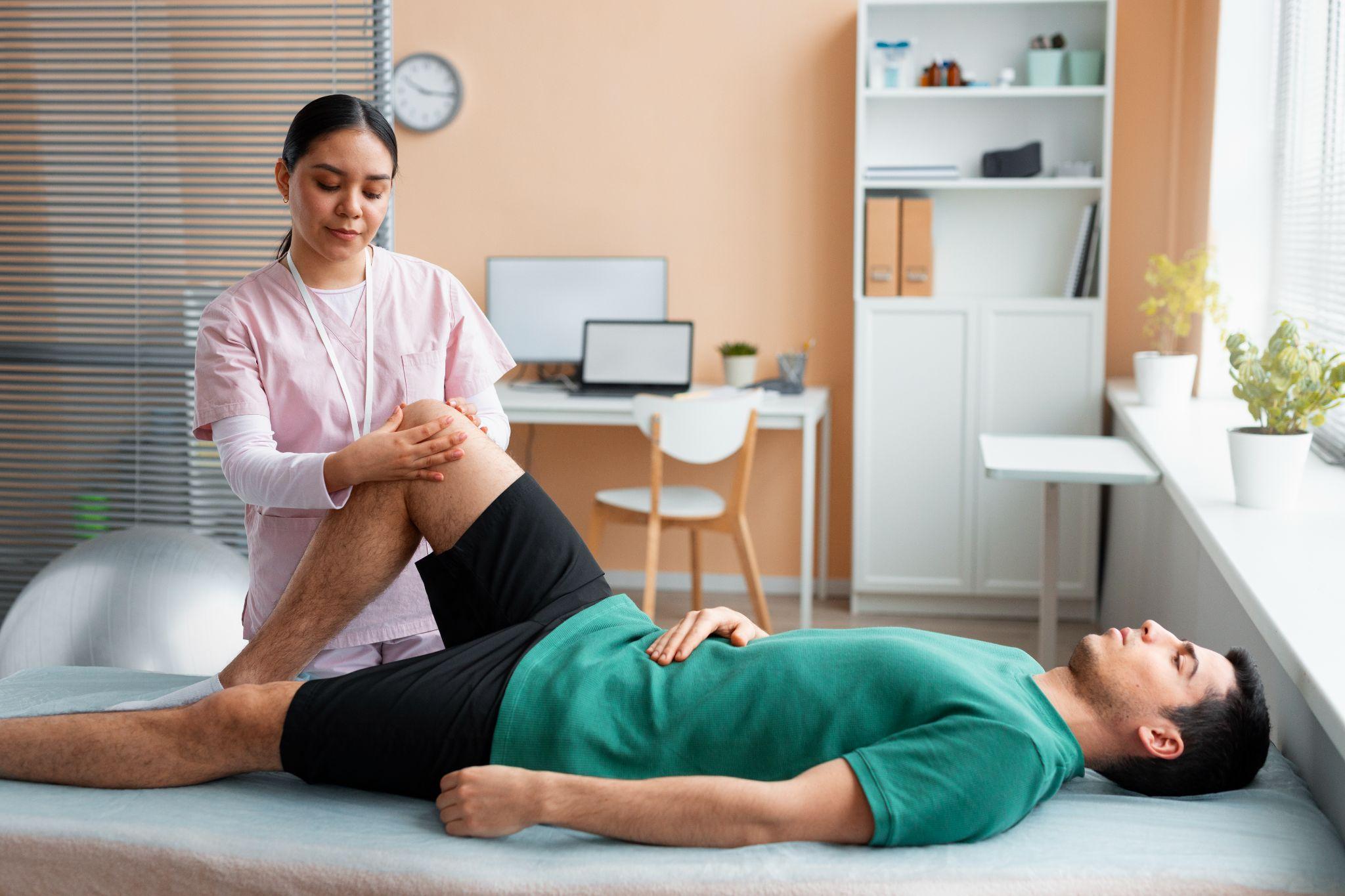 The image depicts a physiotherapist assisting a patient during knee rehabilitation therapy. Physiotherapy helps restore strength, stability, and mobility after ligament injuries.