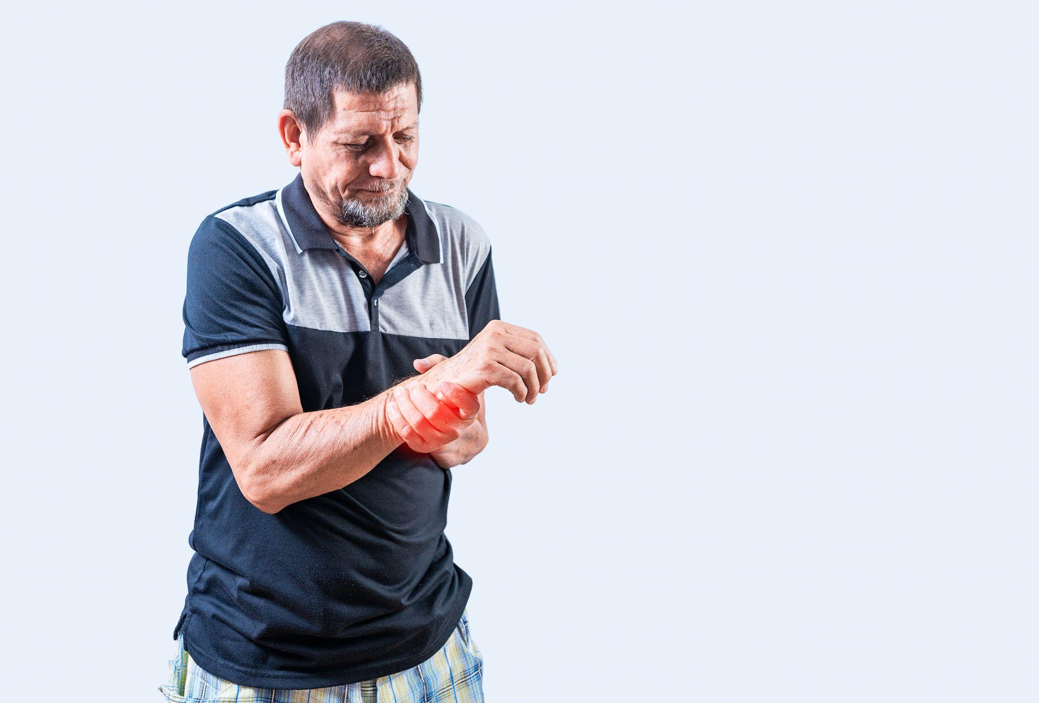 An elderly man experiencing wrist pain, often linked to past fractures and degenerative changes.