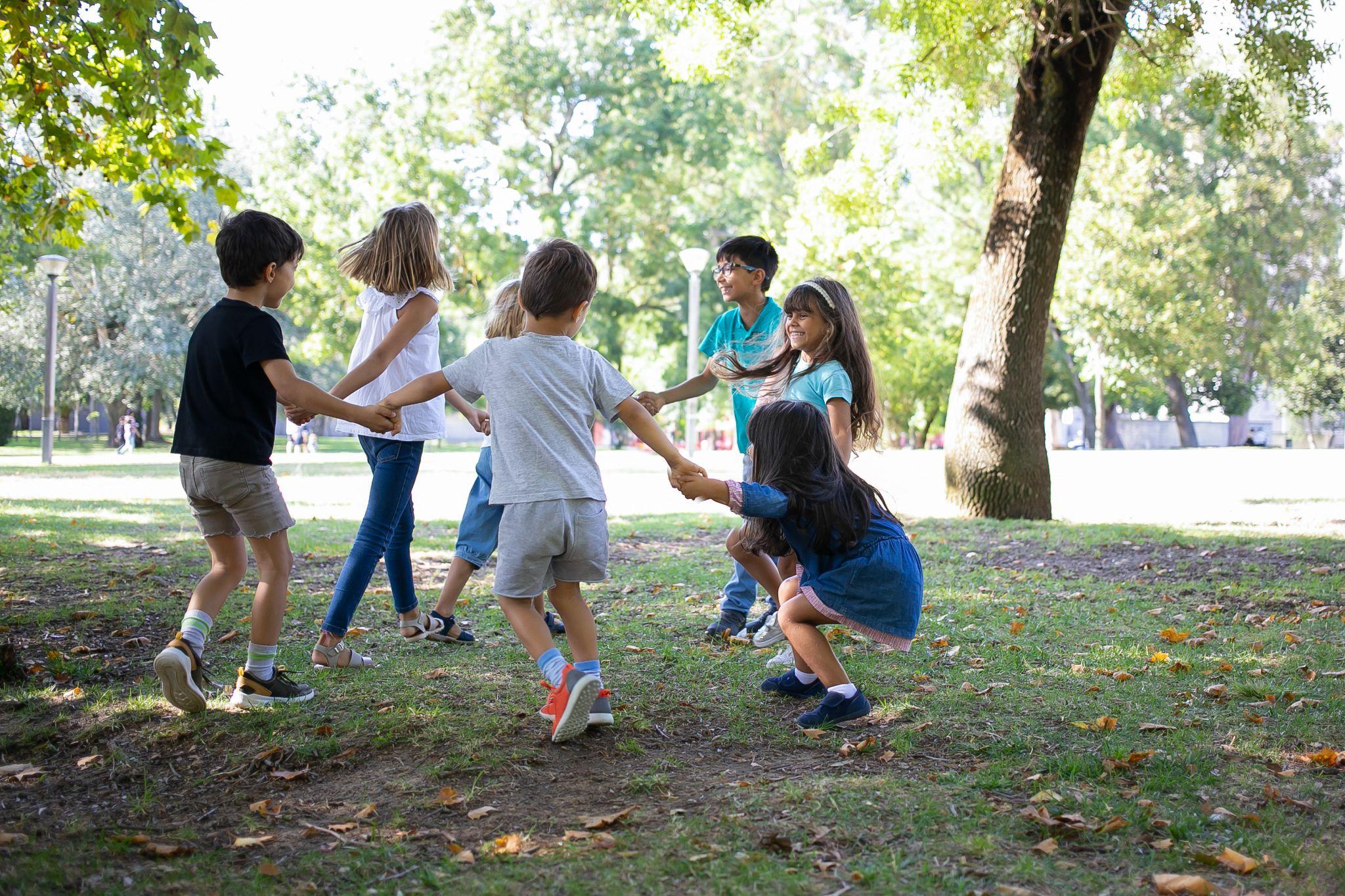 Children playing together outdoors, emphasizing active play and injury prevention from an early age.