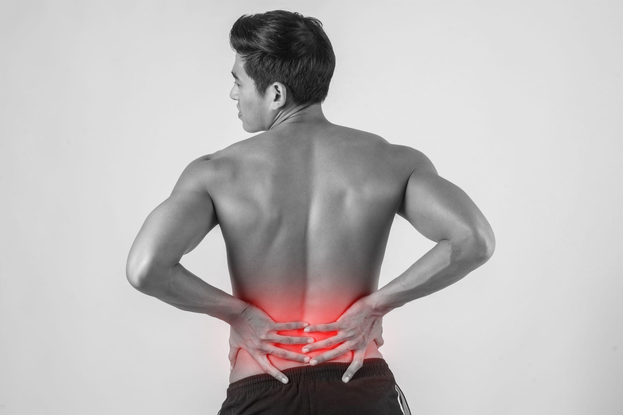 Man experiencing lower back pain possibly linked to hip joint or spine issues.