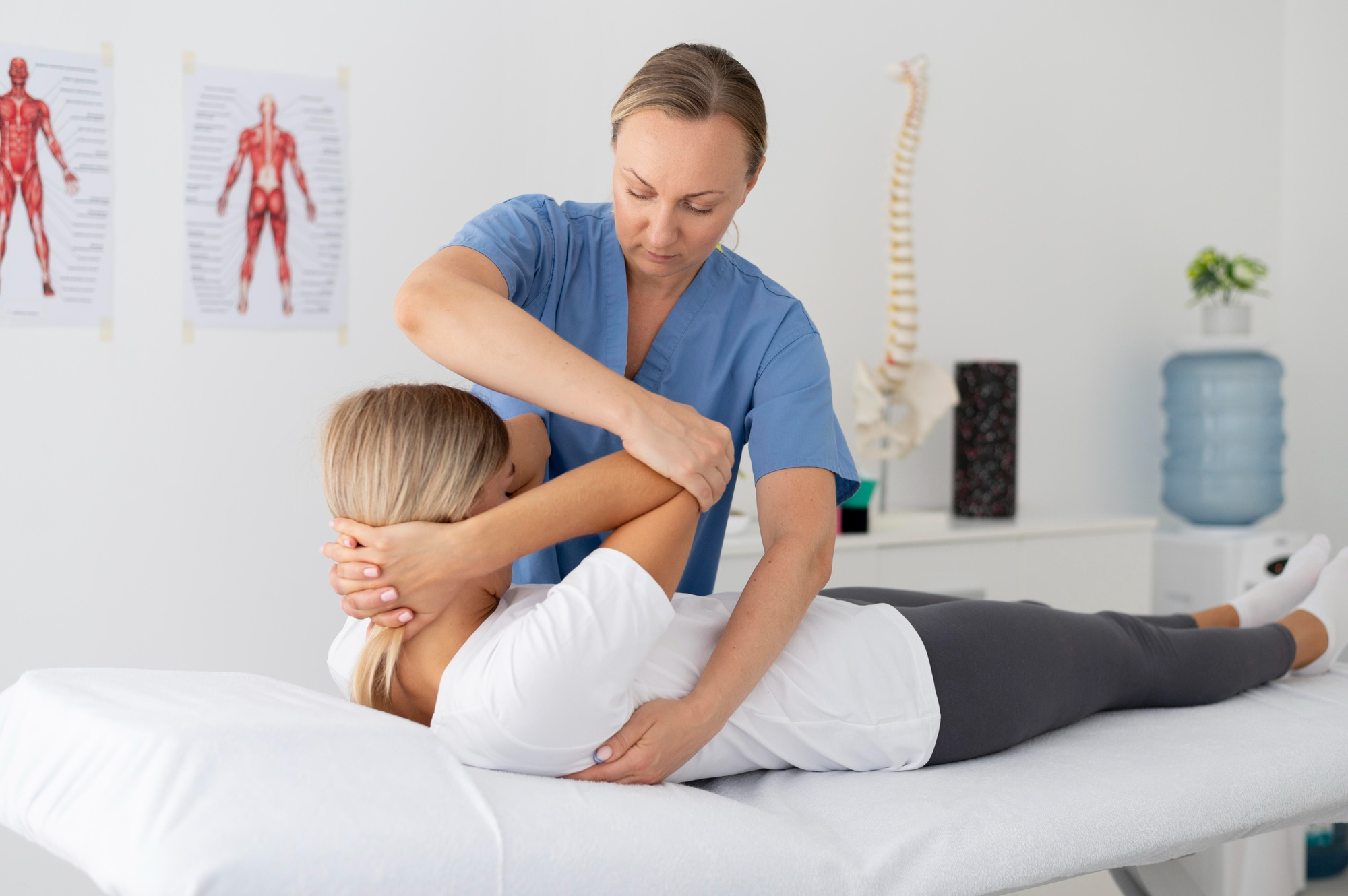A woman in a physiotherapy session, guided by a therapist who helps her perform controlled exercises or stretches.