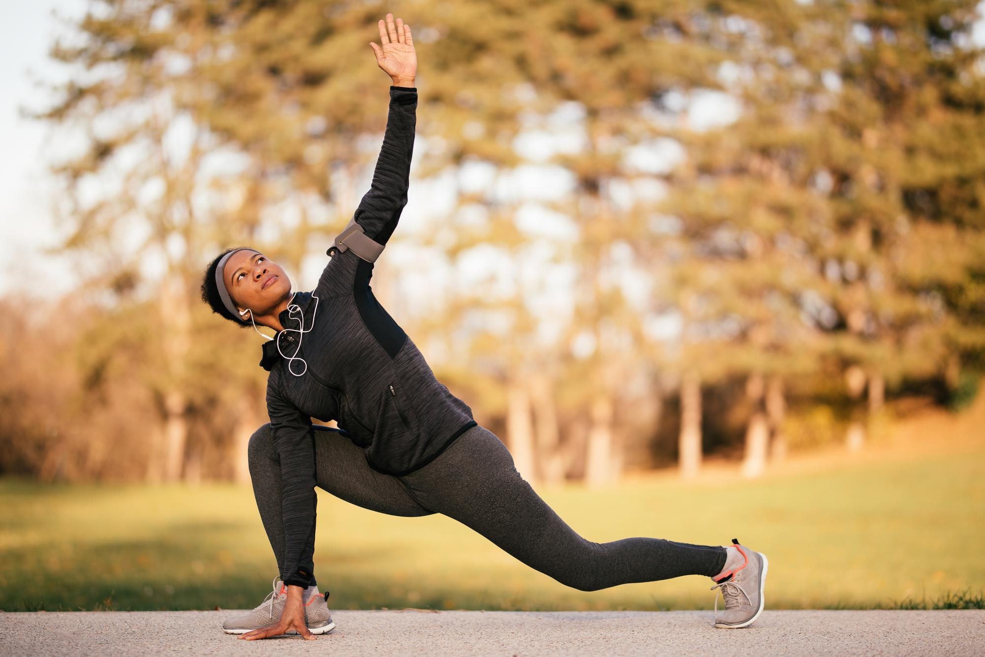 A woman performs warm-up exercises such as stretching or light movements, before starting her workout.