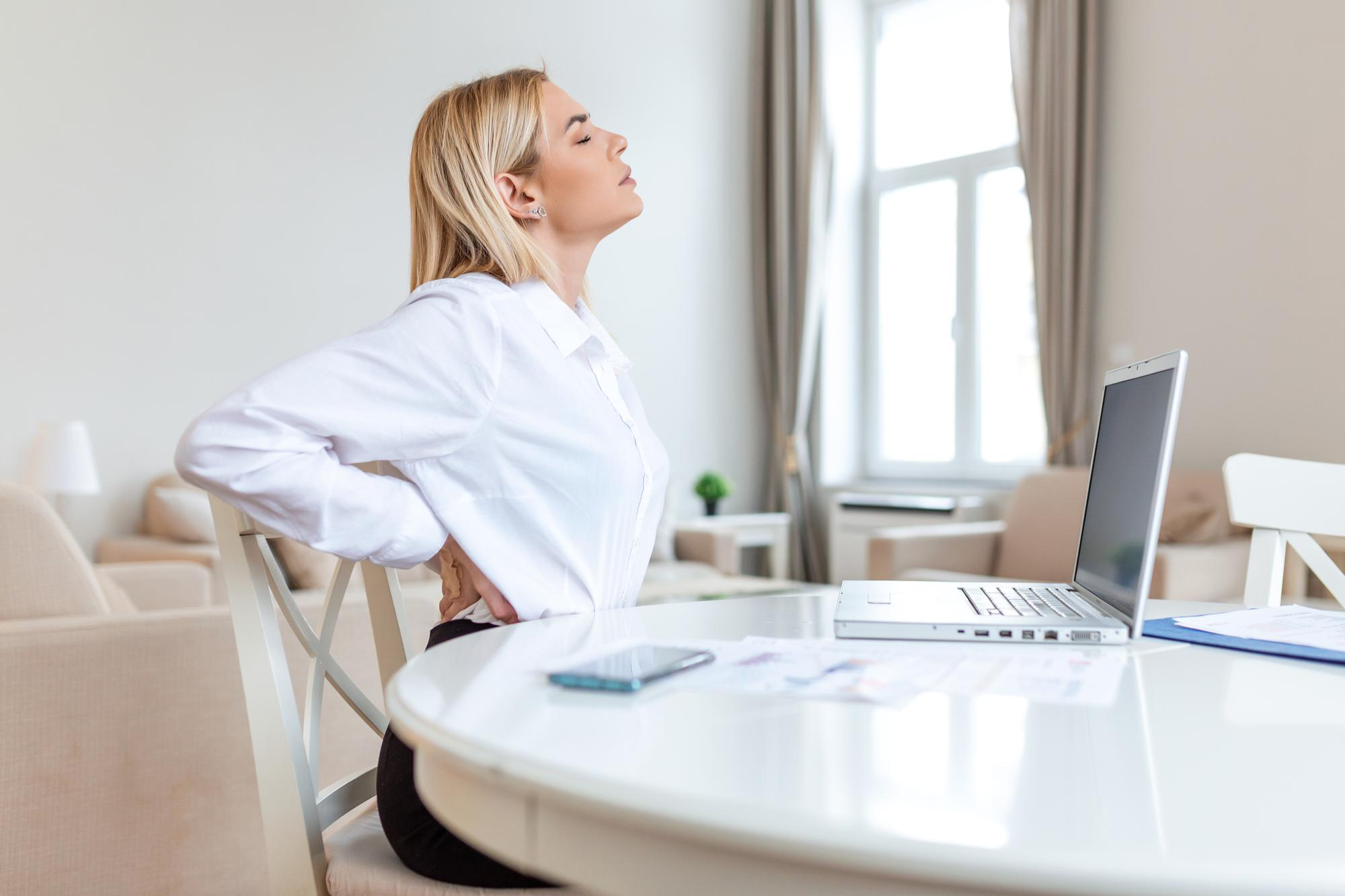 A woman is shown placing her hand on her lower back, indicating discomfort related to poor posture and low bone density.