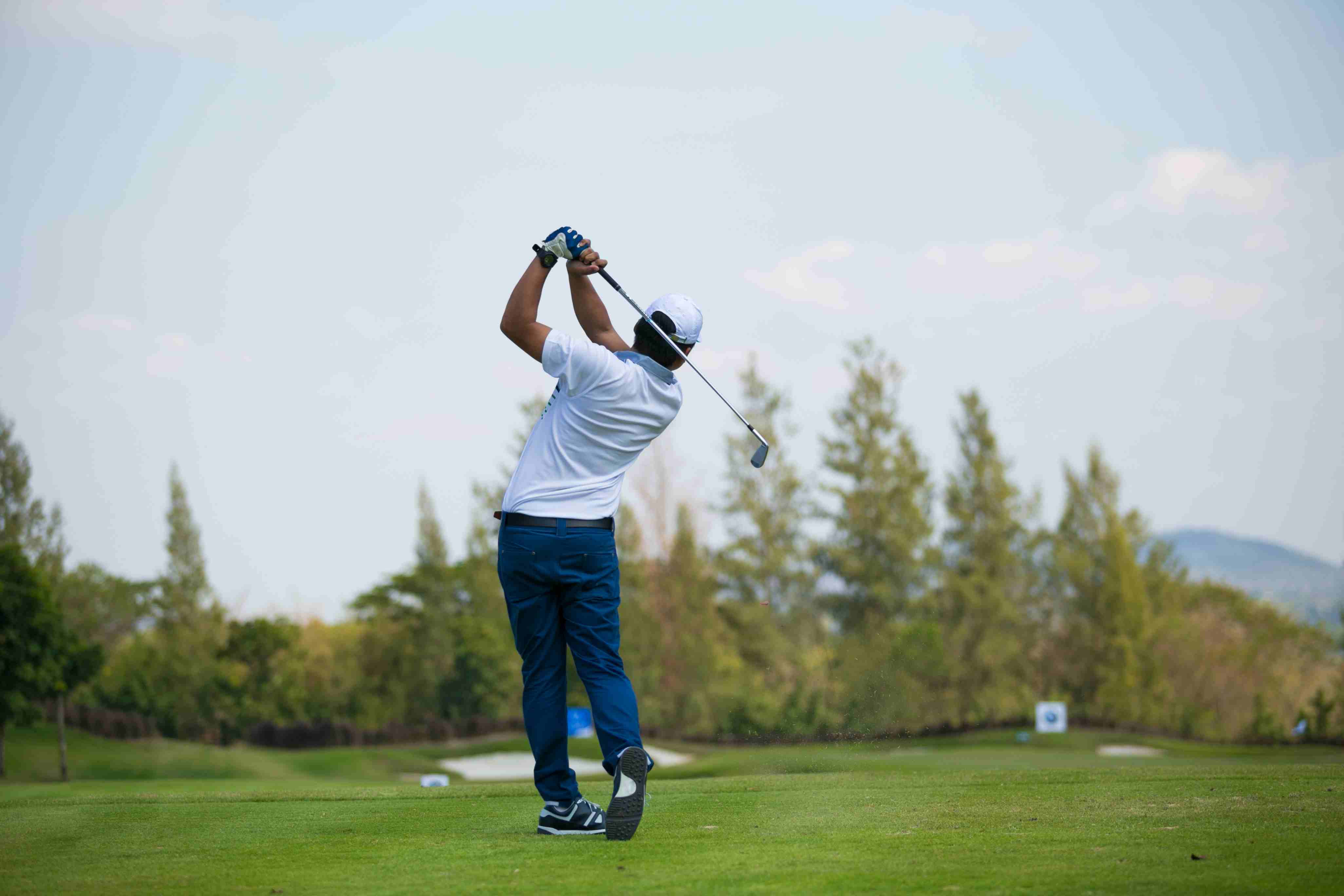 Man playing golf post with no pain after knee surgery, showcasing successful recovery. 