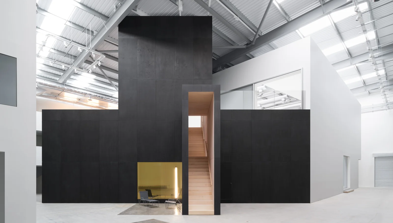 The Gallery Space at Studio Wayne McGregor, a tall white hall with a black tower structure and a wooden staircase inside