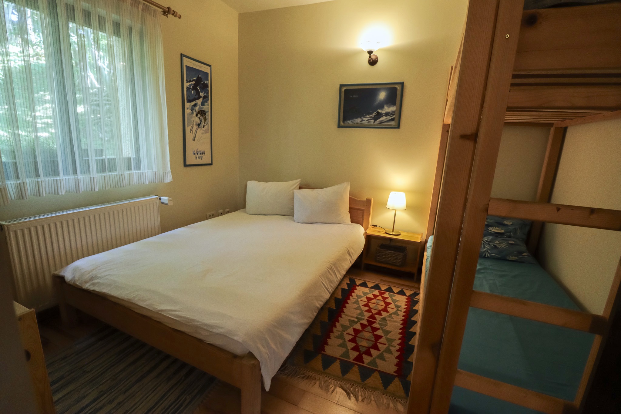 Main bedroom with double bed, warm lighting and wooden walls