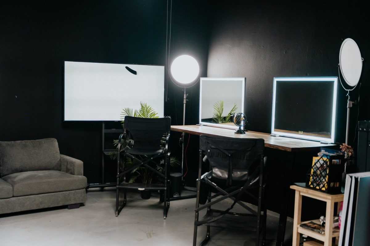 AI Studios preparation area with illuminated mirrors and makeup chairs