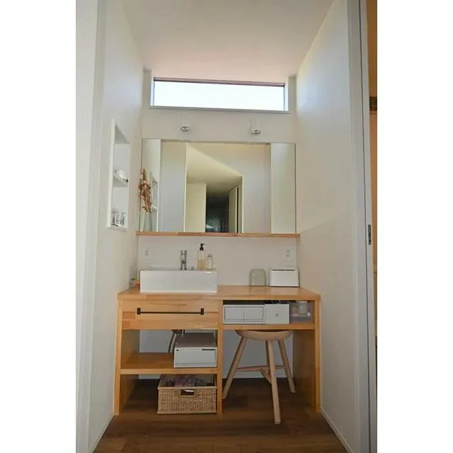 長生村一松中古戸建の洗面室・木製カウンターと鏡のある清潔な洗面空間