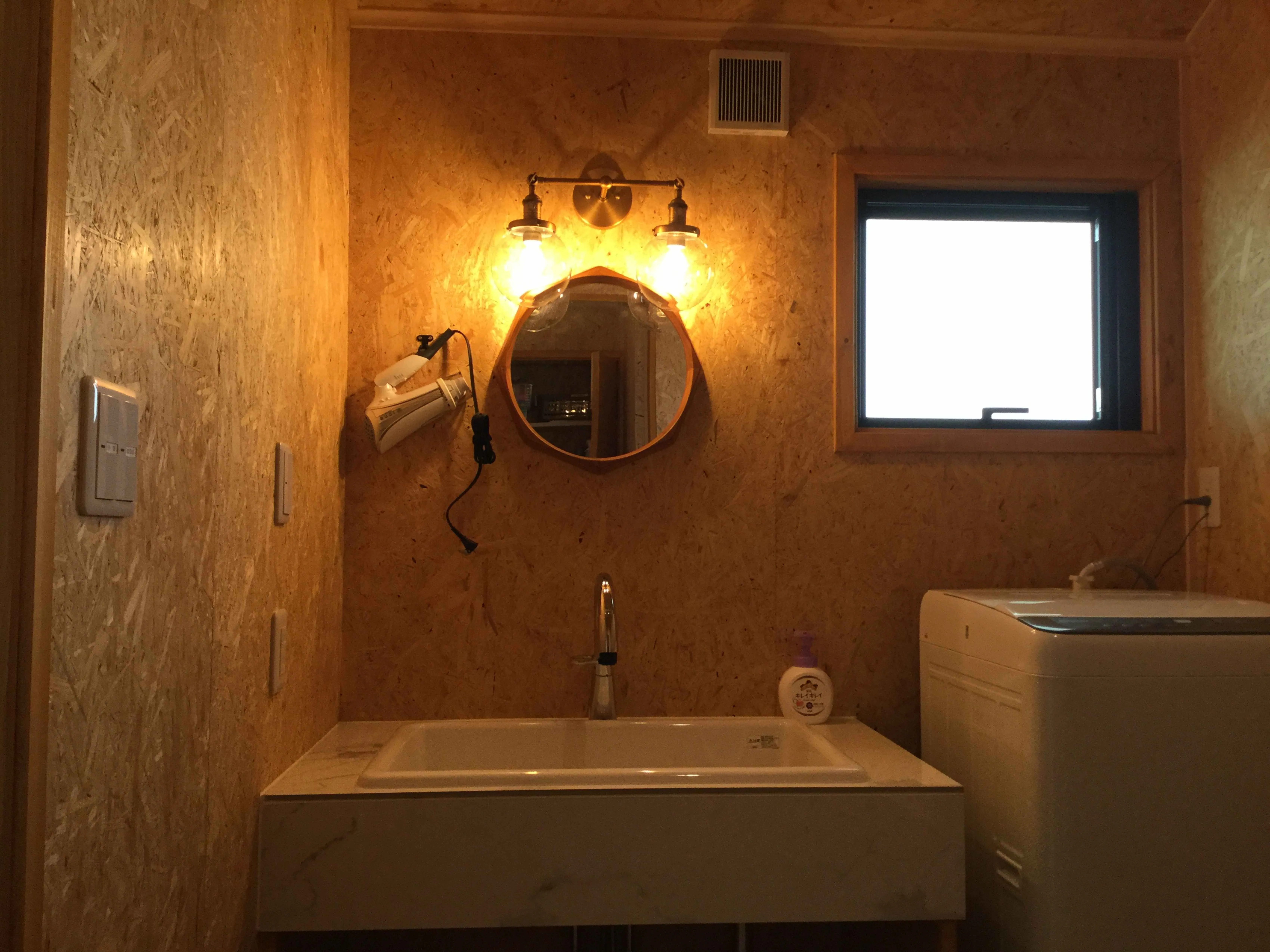 富津市岩本中古戸建の洗面所・温かい照明と丸鏡が印象的