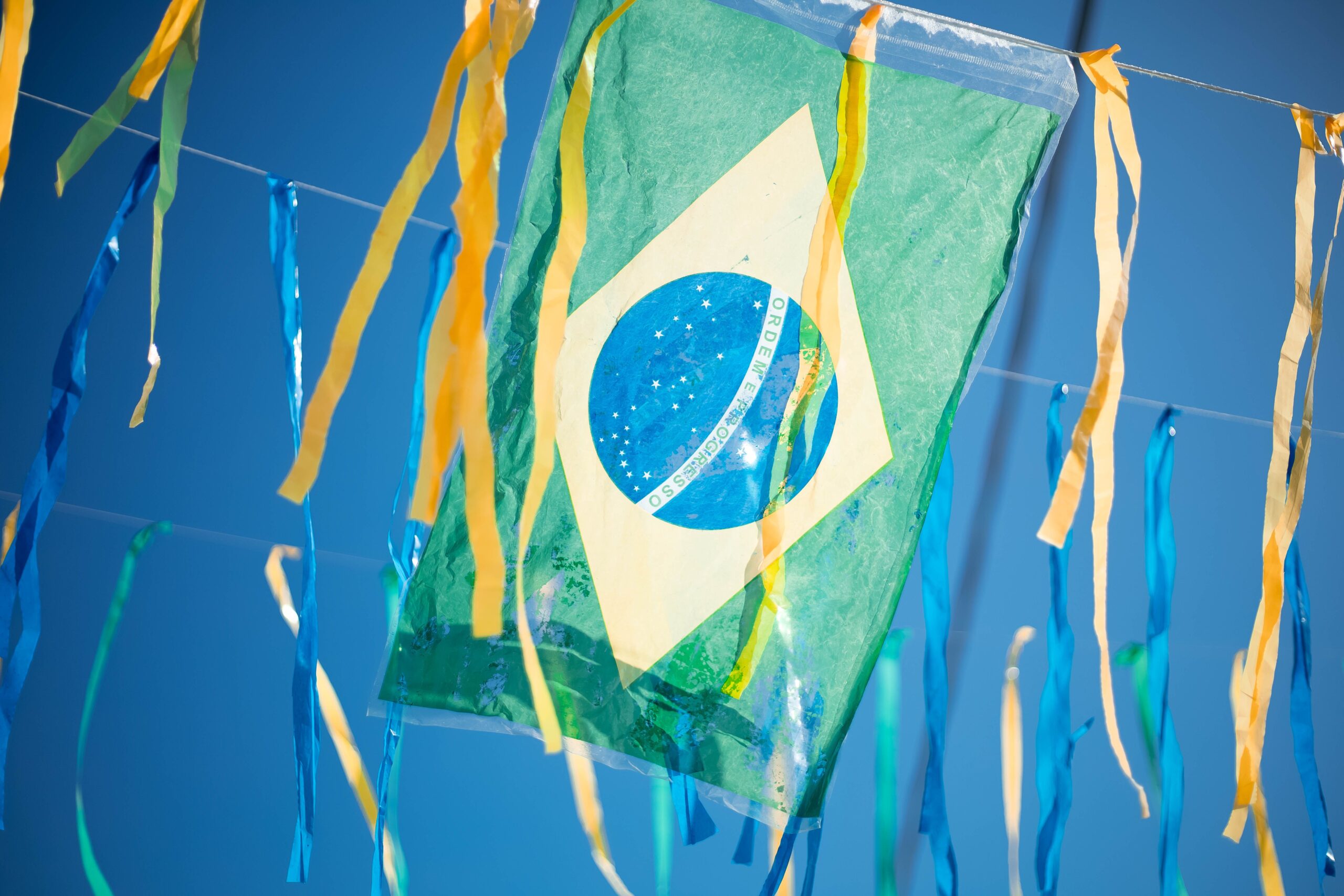 Bandeira do Brasil pendurada em varal decorativo de rua durante a Copa do Mundo, simbolizando a grande escala do evento sustentado por sistemas de engenharia de dados.