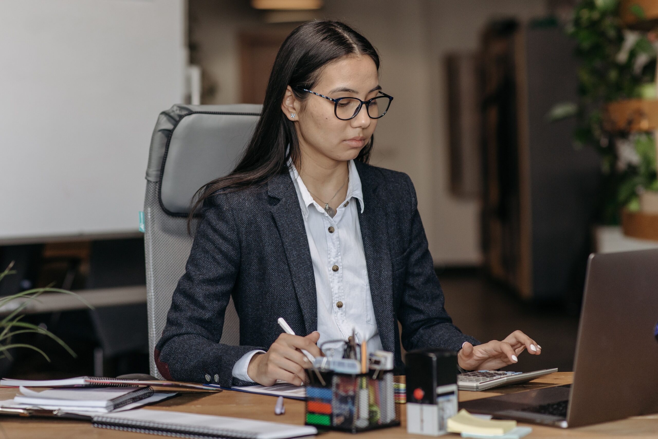 Gestora trabalhando concentrada em seu notebook para implementar a automação de processos e reduzir o tempo gasto com tarefas manuais repetitivas.