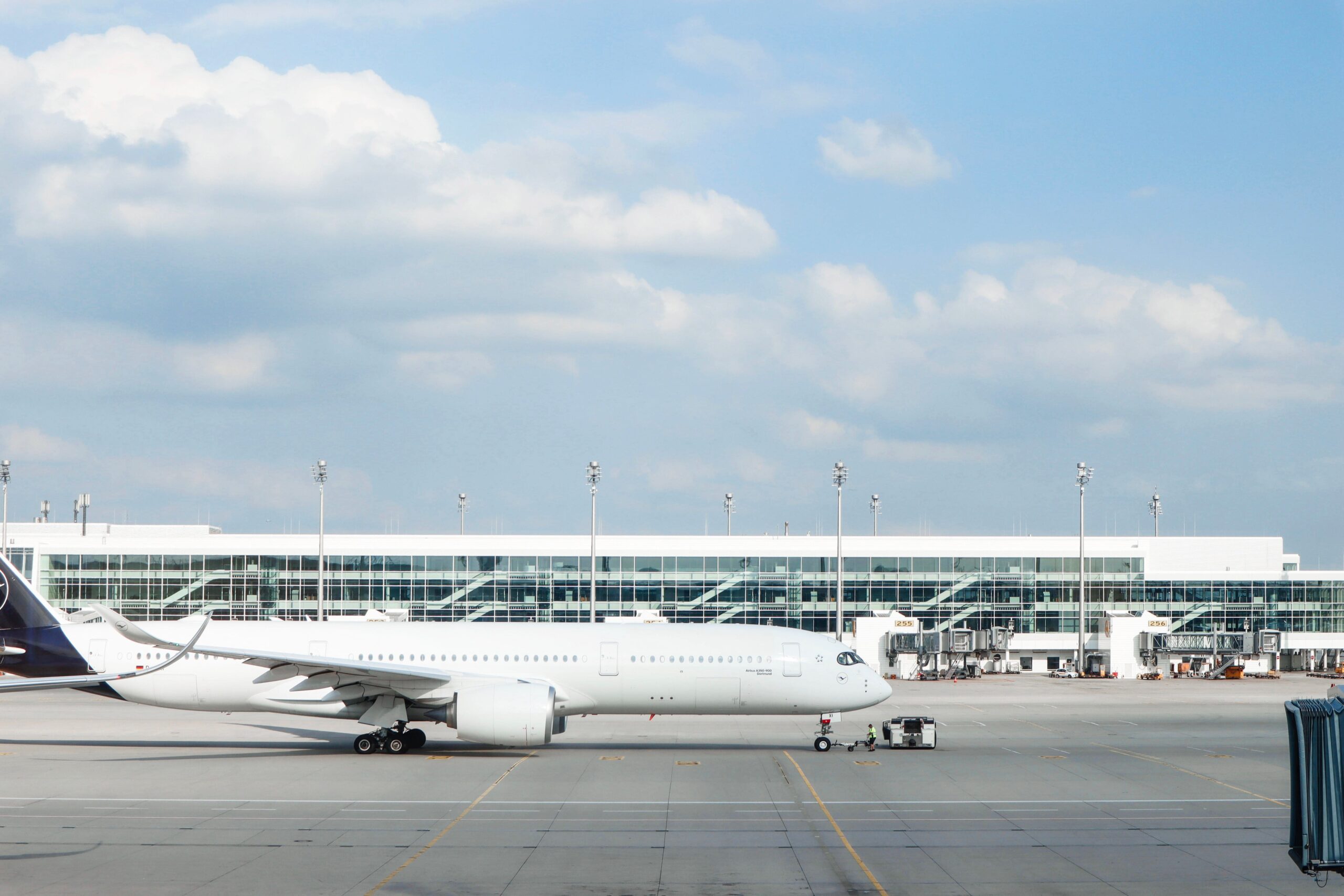 Avião comercial estacionado na pista de um aeroporto moderno, ilustrando a otimização de rotas e o uso de tecnologia preditiva na aviação.