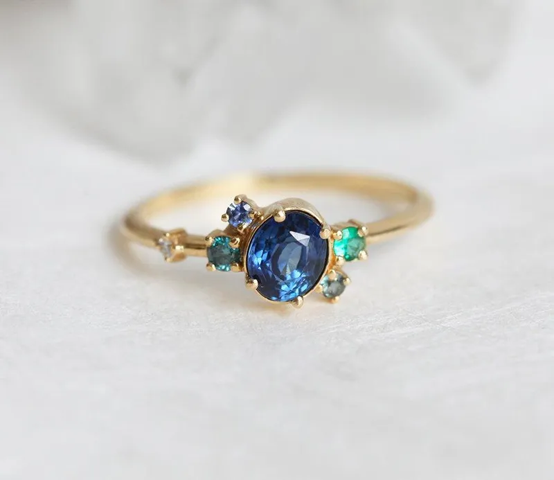 CAPELLA BLUE SAPPHIRE EMERALD DIAMOND CLUSTER RING blue sapphire oval cut engagement ring