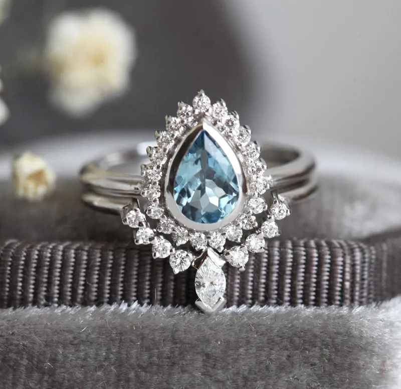 PEAR-CUT AQUAMARINE RING SET WITH DIAMOND HALO AND MARQUISE BAND blue pear cut engagement ring