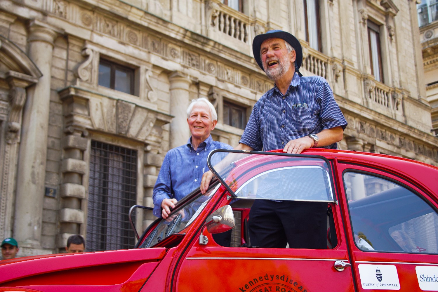 Roger Taylor, the 2CV's Driver for the European leg of the Great Road Trip, and Terry Thompson, KDA President, sharing some laughter with admiring attendees and onlookers.