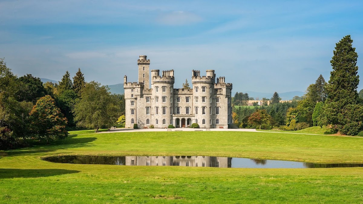 Cluny Castle, Aberdeenshire — the white turreted castle reflected in its pond