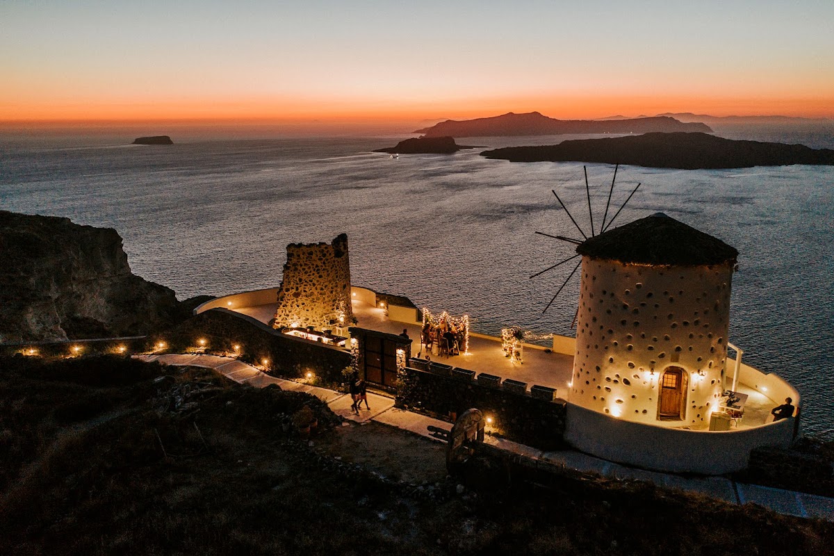 El Viento — restored 200-year-old windmill wedding venue on the Megalochori caldera cliff in Santorini with full sunset views, capacity for 60 guests