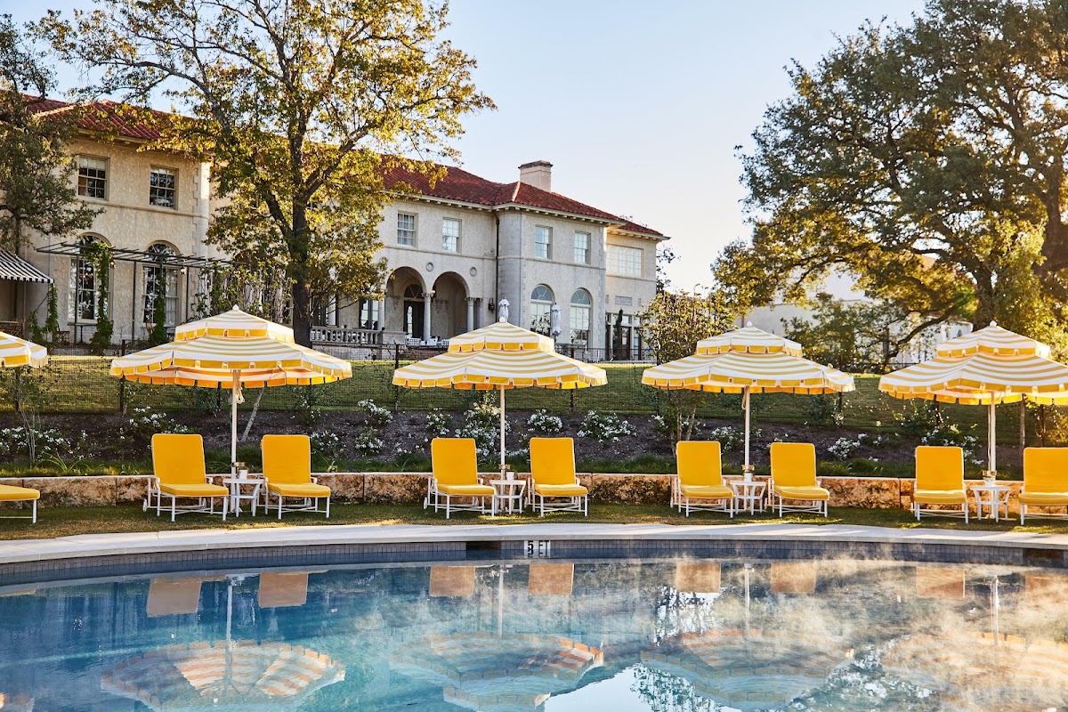 Commodore Perry Estate, Austin — the Mediterranean-style mansion above its pool lined with yellow umbrellas