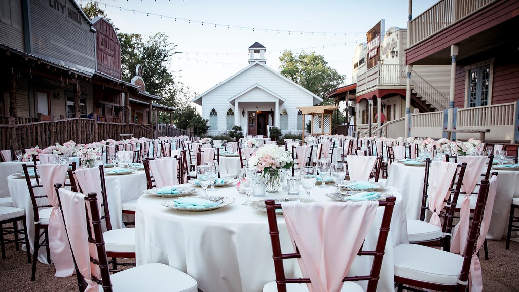 Silver Sycamore, Pasadena — reception tables set on the Western-town street in front of the white chapel