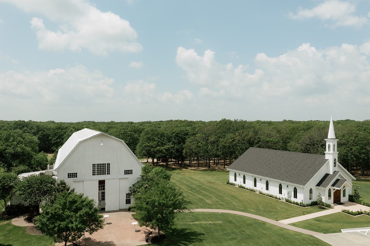 The White Sparrow, Quinlan — an aerial view of the white barn and chapel among the trees