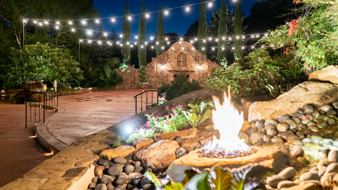 Madera Estates, Conroe — a fire pit and string lights in the hacienda courtyard at night