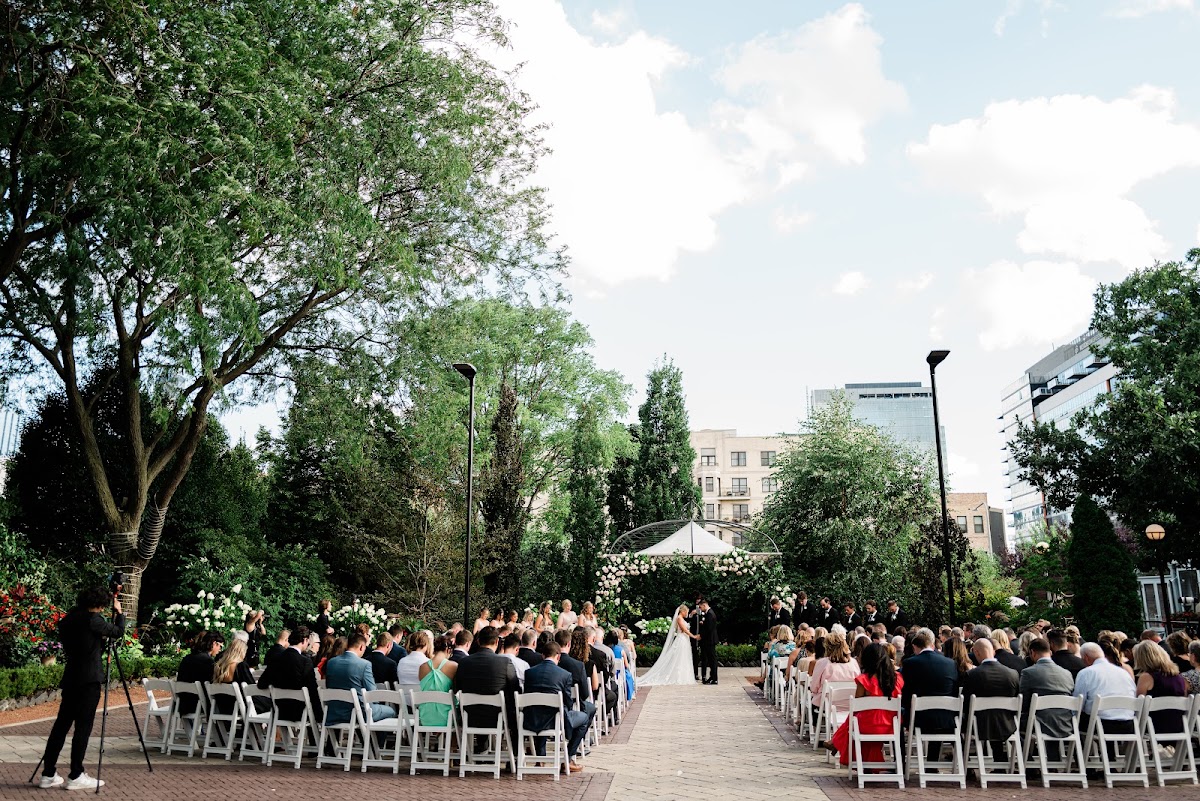 Galleria Marchetti, West Town — an outdoor garden ceremony with the Chicago skyline beyond the trees