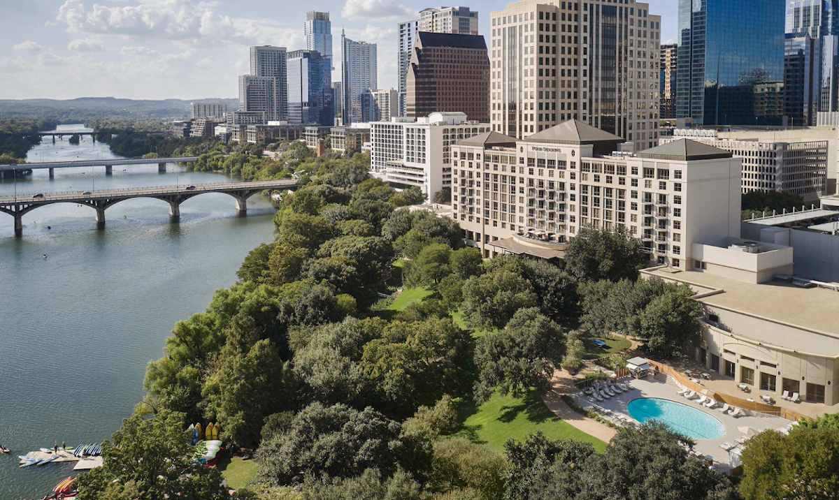 Four Seasons Hotel Austin — the hotel's lakeside grounds on Lady Bird Lake below the downtown skyline