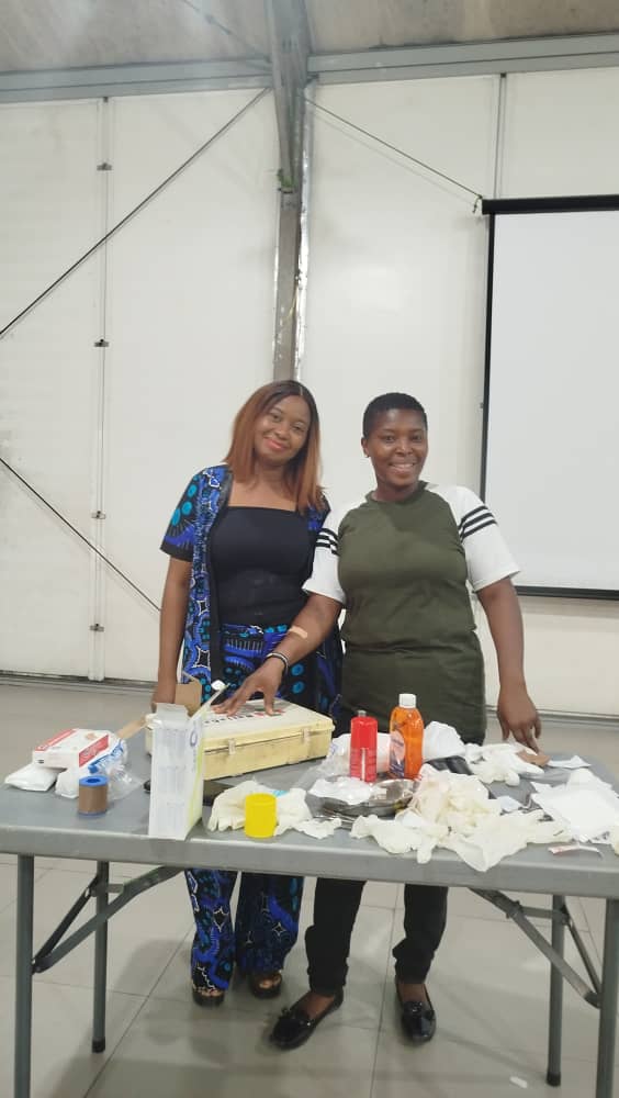 Instructor and student with first aid training supplies on display