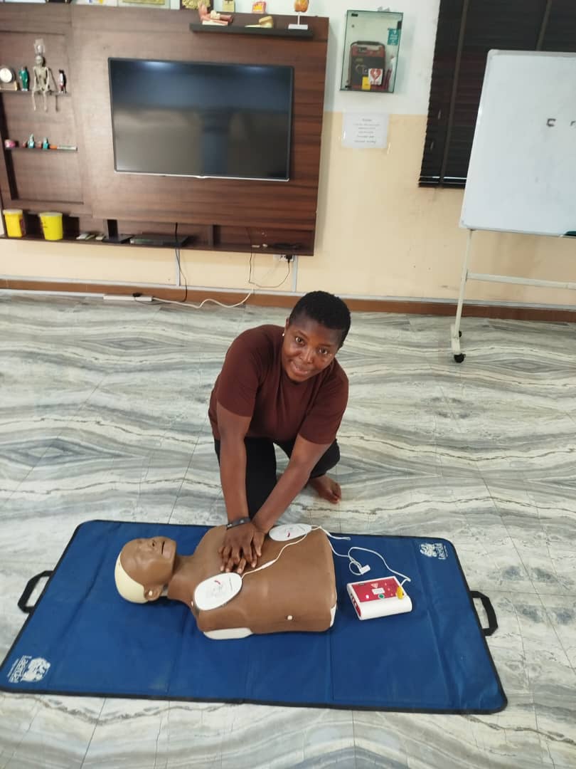 Hands-on CPR practice with AED defibrillator pads on manikin