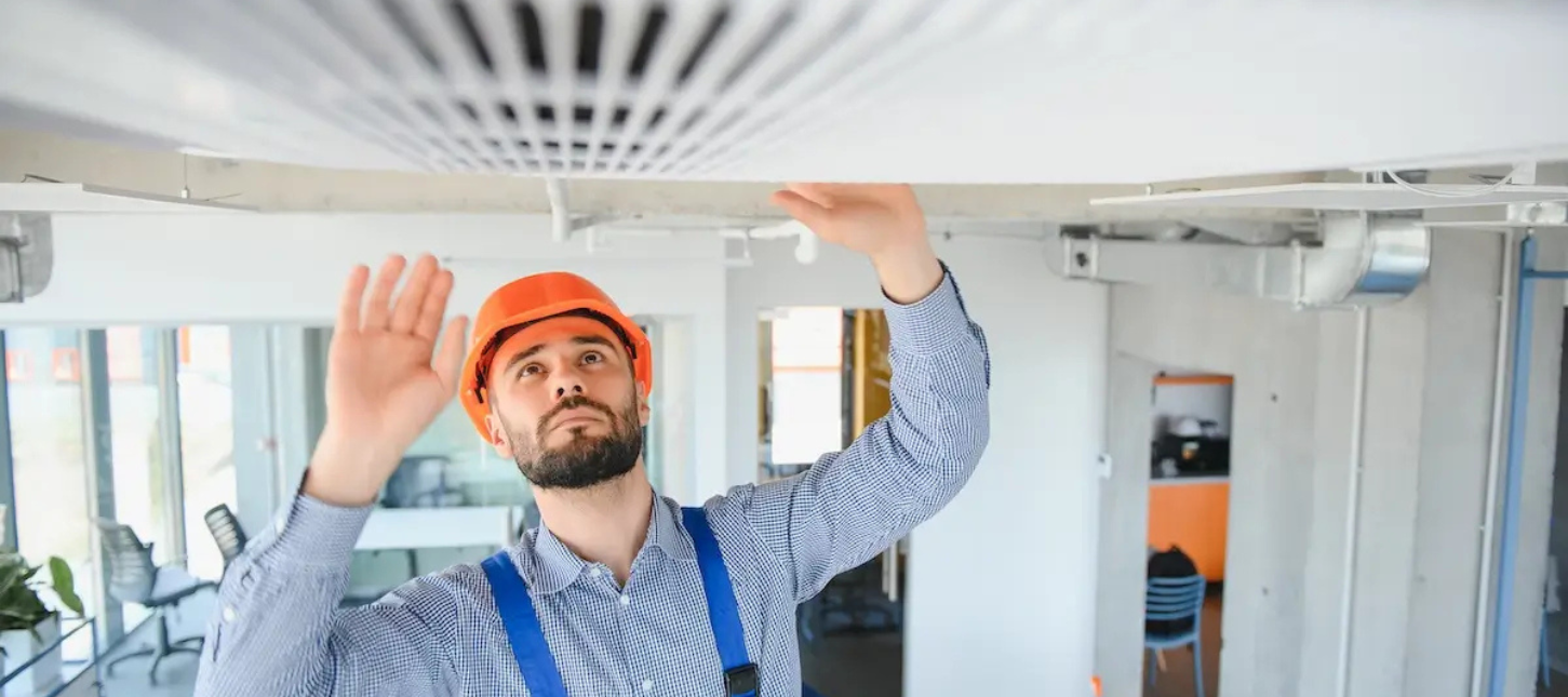 Un homme qui installe une vmc dans une maison