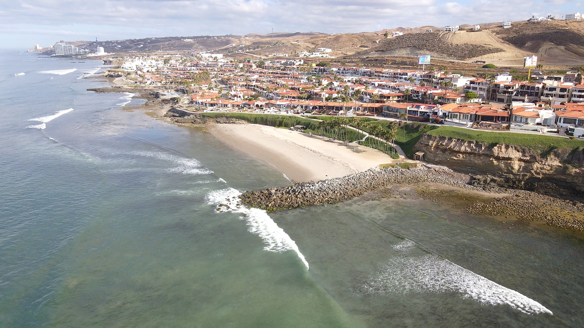 Cobblestone street in a beachfront gated community in Baja California with Pacific Ocean visible in background