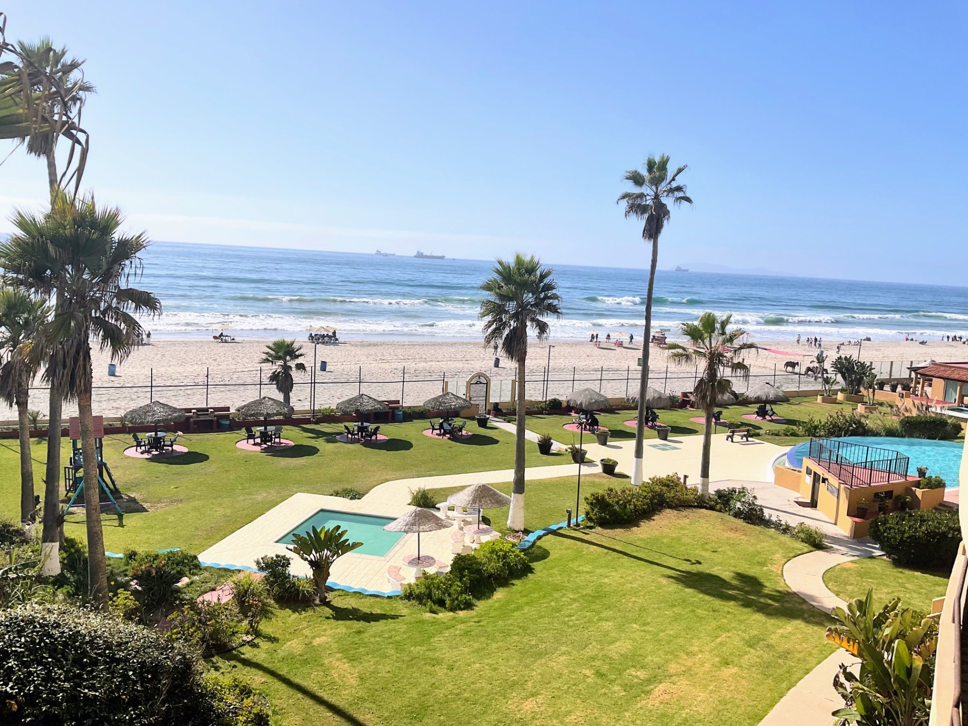 Resort-style pool and clubhouse amenities at a gated condo community in Rosarito Beach