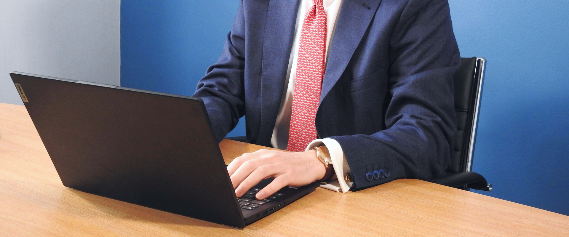An adviser working behind a laptop, typing.