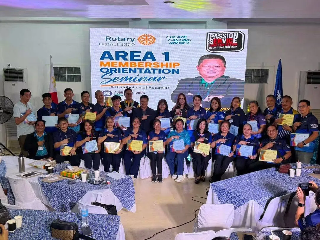 Rotarians gather beneath the Area 1 Membership Orientation Seminar banner.